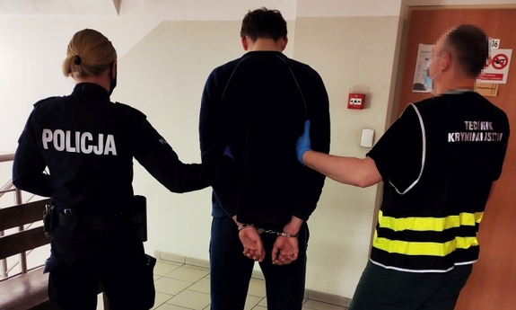 policjant i policjantka prowadzą zatrzymanego mężczyznę