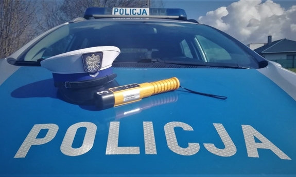 urządzenie do pomiaru trzeźwości oraz policyjna czapka na masce oznakowanego radiowozu