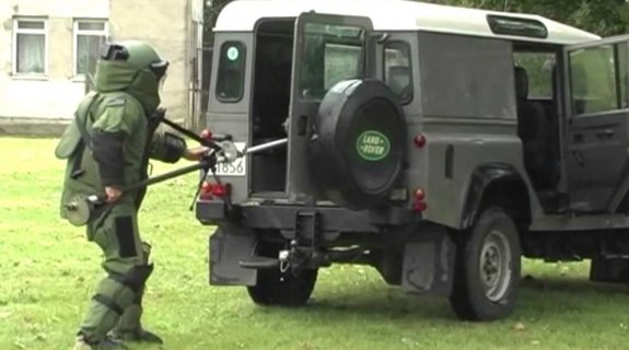 Policyjny pirotechnik stojący obok radiowozu
