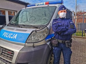 policjant stoi przy radiowozie