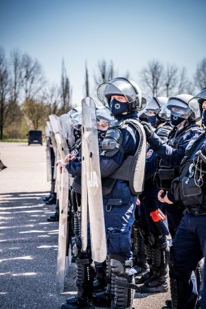 Policjanci z oddziału prewencji z tarczami&quot;&gt;