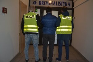 dwaj policjanci prowadzą zatrzymanego mężczynę