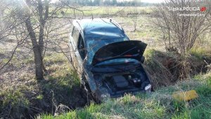 Na zdjęciu widać samochód Fiat Panda, który znajduje się w przydrożnym rowie. Auto ma wgniecenie na dachu, otwartą maskę oraz rozbitą przednią szybę