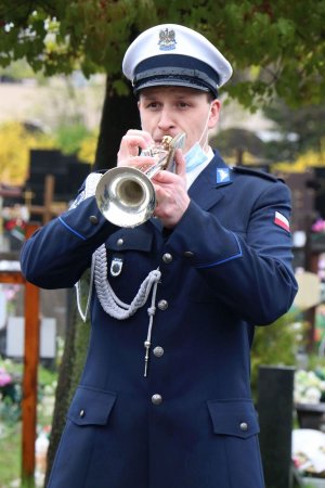 Policjant w trakcie odgrywania pieśni na trąbce.