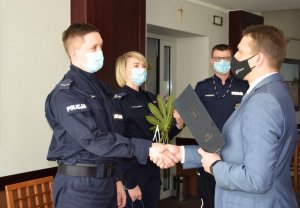 umundurowani policjantka i policjant otrzymują z rąk burmistrza podziękowania