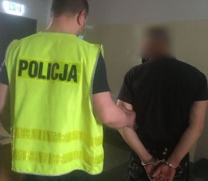 policjant prowadzi zatrzymanego mężczyznę