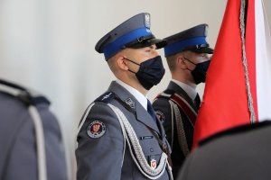 trzej umundurowani policjanci ze sztandarem - poczet sztandarowy