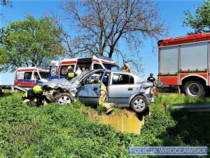 Samochód znajdujący się w przydrożnym rowie oraz służby ratownicze