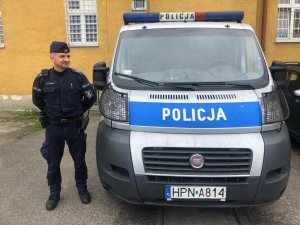 umundurowany policjant stoi przy policyjnym furgonie