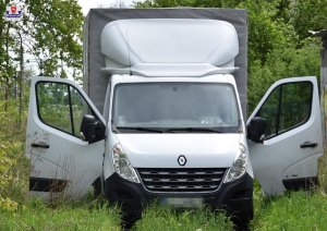 stojący na trawie przy zaroślach samochód marki Renault Master