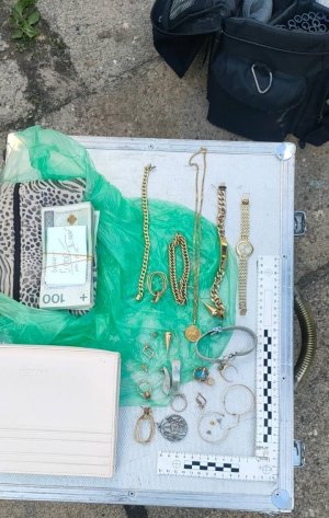 walizka technika kryminalistyki, na której leżą pieniądze i biżuteria zabezpieczone przez policjantów