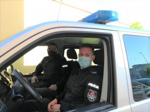 dwaj policjanci siedzący w radiowozie