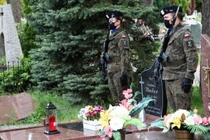 dwoje żołnierzy stoi przy grobie