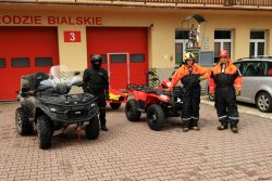 Policjanci i strażacy stoją przy quadach przed OSP w Międzybrodziu Bialskim