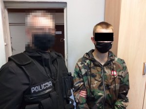 policjant prowadzi zatrzymanego