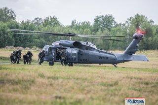 Kontrterroryści prowadzą zatrzymanego do oczekującego Black Hawka.