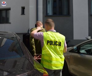 policjant prowadzi zatrzymanego mężczyznę