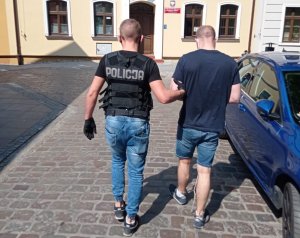 Policjant prowadzi zatrzymanego