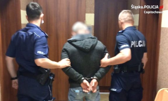 policjanci prowadzą trzymając pod ręce zatrzymanego