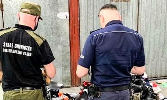 Strażnik graniczny i policjant przy stosie zabezpieczonego, podrobionego obuwia