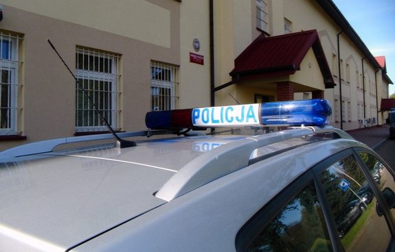 Na zdjęciu radiowóz. W tle budynek sanockiej komendy Policji