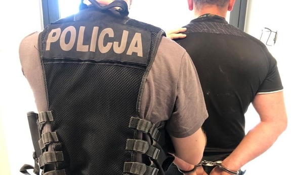 policjant prowadzi zatrzymanego mężczyznę