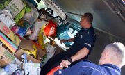 dwaj policjanci wyjmują z samochodu dary dla hospicjum
