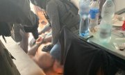 policyjni kontrterroryści trzymają leżącego na podłodze zatrzymanego