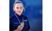 umundurowana policjantka trzyma w reku medal