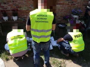 policjanci, funkcjonariusze Pomorskiego Urzędu Celno – Skarbowego w Słupsku z funkcjonariuszami Wojewódzkiego Inspektoratu Ochrony Środowiska ze Słupska sprawdzają dokumentację