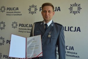 Policjant w ręku trzyma dyplom