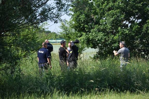 policjanci i osoby ubrane po cywilnemu w trawach