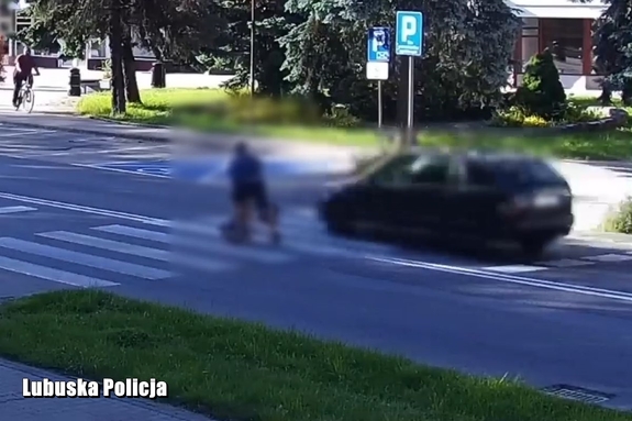 mężczyzna przechodzący przez przejście dla pieszych odskakuje przed samochodem wjeżdżającym na przejście