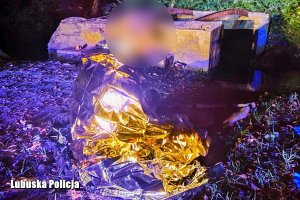 mężczyzna owinięty kocem termicznym