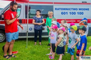 Grupa dzieci stojąca na tle samochodu - Karetki Ratownictwa Wodnego