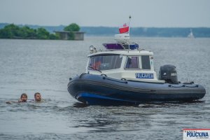 Łódź Policyjna i dwóch mężczyzn w wodzie