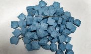 tabletki ecstasy koloru niebieskiego znajdujące się na kartce papieru