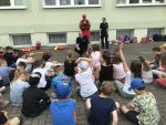 grupa dzieci odpowiadająca na pytania dwójki policjantów oraz ratownika
