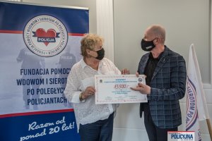 Symboliczny czek z sumą 13 500 zł z rąk pomysłodawcy zawodów mł. insp. w st. spocz. Andrzeja „Pułkownika” Kuczyńskiego odbiera prezes Fundacji Pomocy Wdowom i Sierotom po Poległych Policjantach Irena Zając