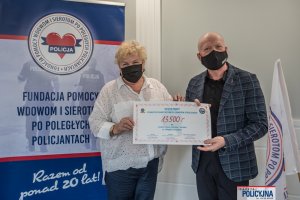 Symboliczny czek z sumą 13 500 zł z rąk pomysłodawcy zawodów mł. insp. w st. spocz. Andrzeja „Pułkownika” Kuczyńskiego odbiera prezes Fundacji Pomocy Wdowom i Sierotom po Poległych Policjantach Irena Zając