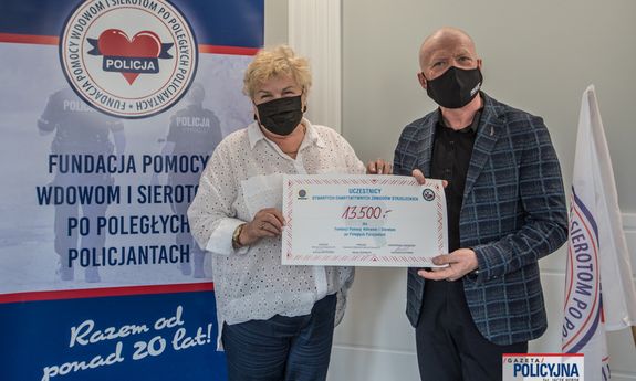 Symboliczny czek z sumą 13 500 zł z rąk pomysłodawcy zawodów mł. insp. w st. spocz. Andrzeja „Pułkownika” Kuczyńskiego odbiera prezes Fundacji Pomocy Wdowom i Sierotom po Poległych Policjantach Irena Zając
