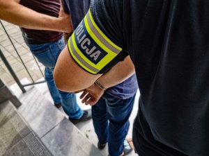 POLICJANT W CYWILNYCH UBRANIACH ZAKŁADA KAJDANKI NA RĘCE