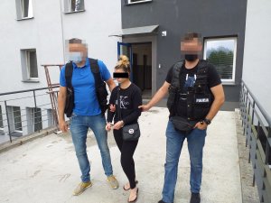 dwaj policjanci prowadzą zatrzymaną kobietę