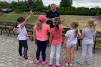 dzieci zgłaszające się do odpowiedzi na pytania policjantki