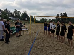 dzielnicowy rozmawia z uczestnikami turnieju siatkówki plażowej
