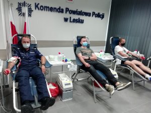policjant i dwaj inni mężczyźni podczas oddawania krwi