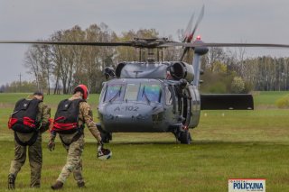 Dwaj funkcjonariusze BOA idą w kierunku śmigłowca.