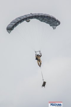 Funkcjonariusz BOA w trakcie skoku ze spadochronem z podwieszonym zasobnikiem.