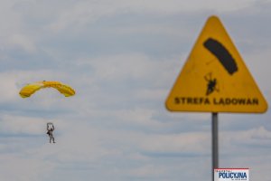 funkcjonariusz &amp;quot;BOA&amp;quot; ląduje na lotnisku ze spadochronem, na pierwszym planie rozmazany znak z napisem strefa lądowań