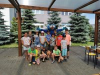 grupa dzieci pozuje do zdjęcia z maskotką policyjną